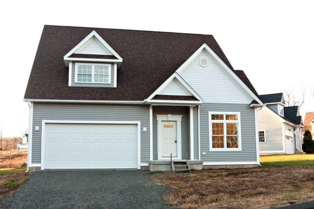 An exterior of a gray and white house with an attached garage.