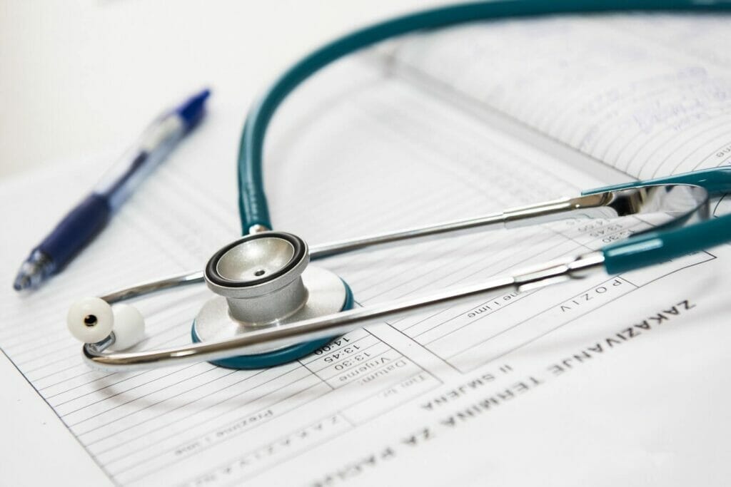 Close-up image of a patient's record, a stethoscope, and pen