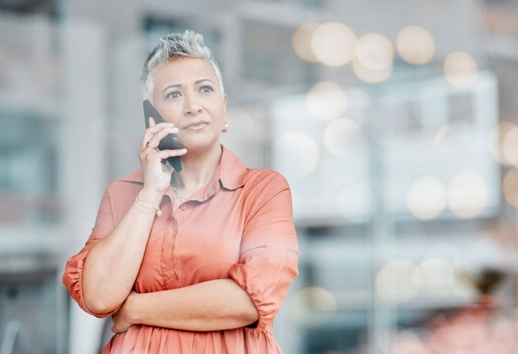 An older adult woman is talking on her cell phone.