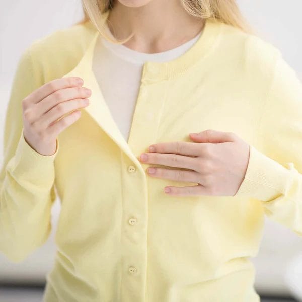Image of a woman wearing a MagnaReady cardigan, showing that the buttons do not go all the way through as there are magnets in the seams.